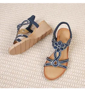 Detail of bohemian wedge sandals with blue rhinestones and beadwork on braided straps