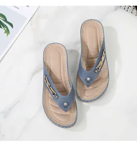 Close-up of Morandi blue flip flops with metal chain, rhinestones and perforated PU leather
