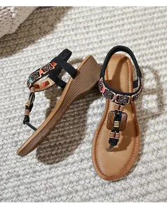 Detail of bohemian wedge sandals featuring colorful beads and vintage floral metalwork