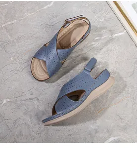 Detail of grey-blue leather sandals with breathable laser-cut holes and adjustable backstrap