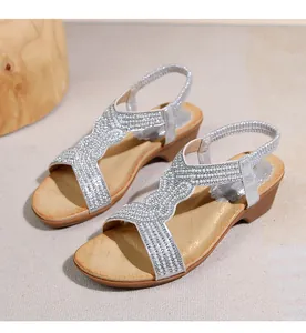 Dettaglio sandali con zeppa argento con perle e strass su cinturini ondulati