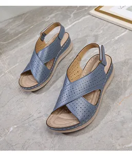 Close-up of women's summer wedge sandals with blue perforated straps and velcro closure
