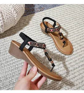 Detail of bohemian wedge sandals with floral beadwork and elastic back strap