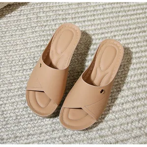 Detail of beige criss-cross strap slide sandals with gold buckle and quilted footbed