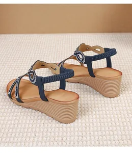 Close-up of bohemian wedge sandals featuring blue straps and sparkling rhinestone rings