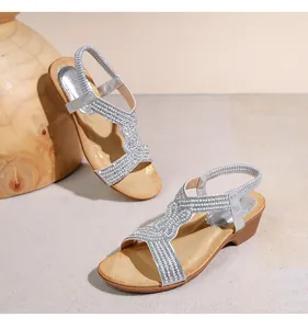 Dettaglio di sandali con zeppa argento con strass e plateau effetto venature del legno