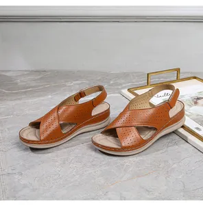 Detail of brown wedge sandals with laser-cut straps and adjustable velcro heel strap