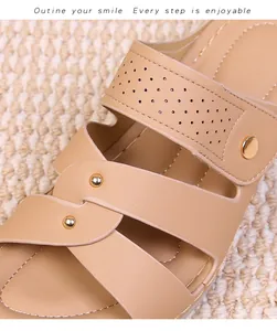 Detail of beige leather strap sandals featuring hollow punching and gold metal rivets
