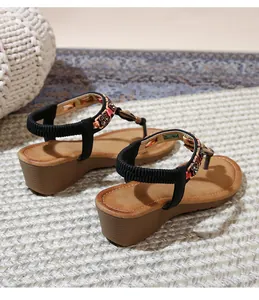 Detail of bohemian wedge sandals featuring floral beadwork and woven ethnic embellishments
