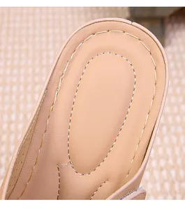 Detail of double stitching and breathable perforations on a tan wedge sandal footbed