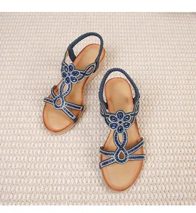 Close-up of bohemian wedge sandals with sparkling blue rhinestones and floral patterns