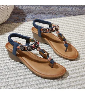 Detail of bohemian wedge sandals featuring ethnic beads and bronze flower embellishments