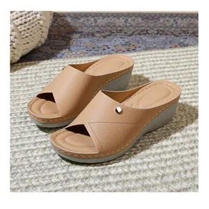 Detail of beige wedge slide sandal showing faux leather texture and metal buckle