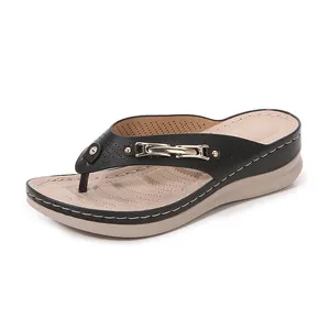 Women's wedge flip flops with black leather upper, gold chain, and breathable perforations