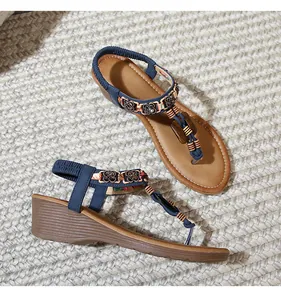 Detail of Bohemian platform sandals with vintage floral buckle and colorful beaded straps