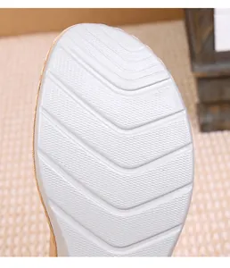 Close-up of silver wedge sandal sole with hexagonal anti-slip pattern and V-shaped grooves
