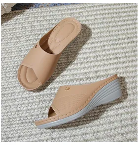 Detail of wedge sandals with laser-cut texture, metal buckle and stitched footbed