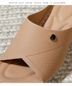 Detail of beige wedge sandals featuring decorative gold buckle and perforated leather texture