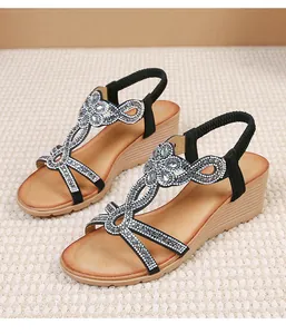 Detail of bohemian wedge sandals with rhinestone flowers and elastic straps