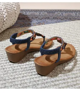 Side view of bohemian navy blue wedge sandals with ethnic patterns and elastic heel straps