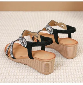 Detail of bohemian black wedge sandals with sparkling rhinestones and elastic heel strap