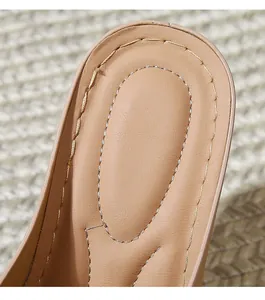 Detailed close-up of beige wedge sandals featuring high-quality double stitching and leather texture