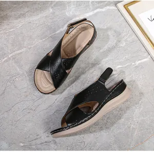 Detailed view of women's black wedge sandals featuring perforated straps and velcro heel strap