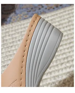Detail of silver wedge sandals showing yellow stitching and non-slip texture