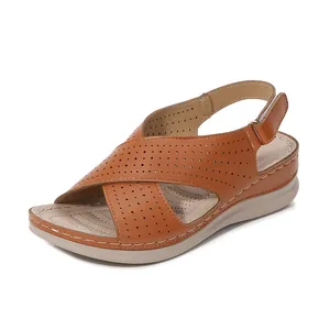 Brown wedge sandals with laser-cut cross straps and adjustable hook-and-loop closure