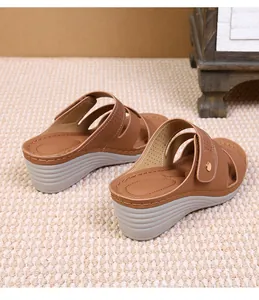 Detail of brown wedge sandals with breathable perforated straps and a thick gray sole