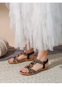 Dettaglio di sandali piatti boho con perline etniche e cinturino elastico sul tallone