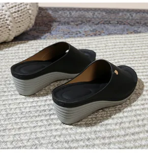 Detailed close-up of a black platform wedge sandal featuring a gold stud and non-slip sole