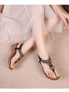Detail of bohemian wedge sandals with intricate vintage beads and metal heart charms