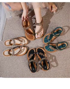 Detail of bohemian flat sandals with floral beadwork and ethnic embroidery trim