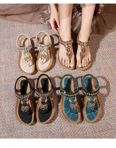 Detail of bohemian flat sandals featuring colorful beads and metal butterfly charms