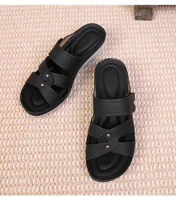 Detail view of black wedge sandals with gold stud accents and crisscross straps for women