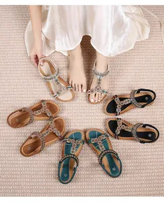 Detail van bohemian platte sandalen met kleurrijke kralen, borduursels en strass-accenten