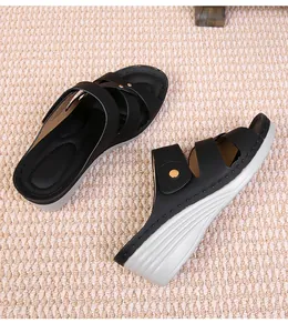 Macro view of wedge sandals with crisscross black straps and gold stud details