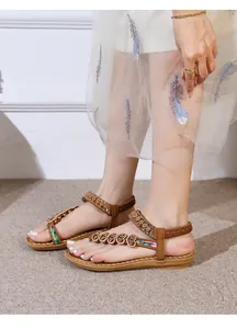 Detail of bohemian flat sandals with ethnic print straps and floral beaded ornaments