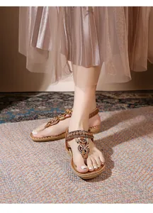 Detail of bohemian flat sandals featuring ethnic beadwork and embroidery on feet