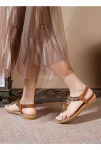 Detail view of Bohemian flat sandals with colorful beads and metallic flower accents