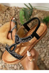 Détail de sandales bohèmes plates avec des strass et des perles sur des brides élastiques