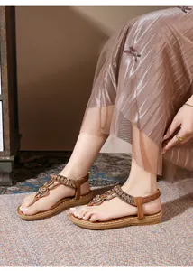 Close-up of Bohemian flat sandals with sparkling rhinestones and beaded T-strap design
