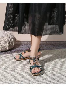 Dettaglio di sandali boho con cinturini incrociati, perline colorate e decori in metallo