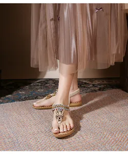 Detail of bohemian flat sandals with ethnic beads, metal discs and stitched soles
