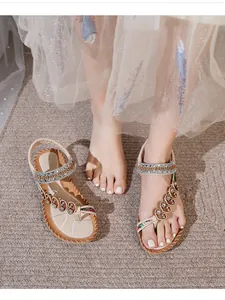 Detail of bohemian flat sandals featuring rhinestone flowers and ethnic woven straps