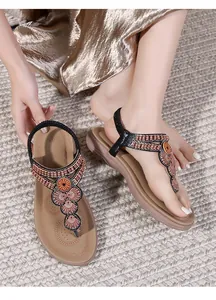Detail of bohemian flat sandals with ethnic beadwork and elastic back straps