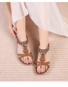 Λεπτομέρεια από boho σανδάλια με έθνικ χάντρες, καρδιές και λευκές ραφές
