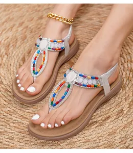 Close-up of bohemian T-strap sandals with colorful beads and rhinestone detailing
