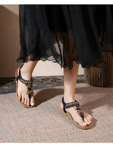 Detail of bohemian flat sandals with ethnic embroidery and butterfly bow ornament